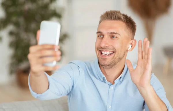 ビデオ通話や手を振るために携帯電話を使用して幸せな男 — ストック写真