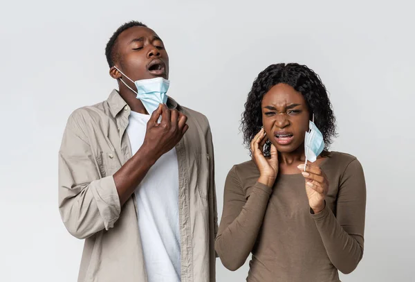 Black couple removing face masks for sneezing