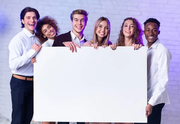 Jóvenes Multiraciales sosteniendo afiche en blanco para texto en interiores, burla —  Fotos de Stock