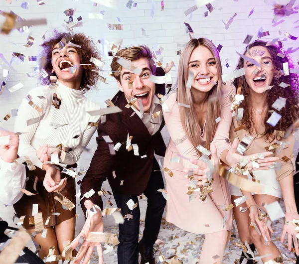 Amici multietnici che si godono la vita festeggiando sotto la doccia con la caduta di Confetti Indoor — Foto Stock