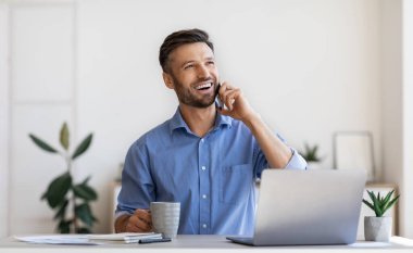 Neşeli Milenyum İş Adamı Ofiste Cep telefonu ve Kahveyle Dinleniyor