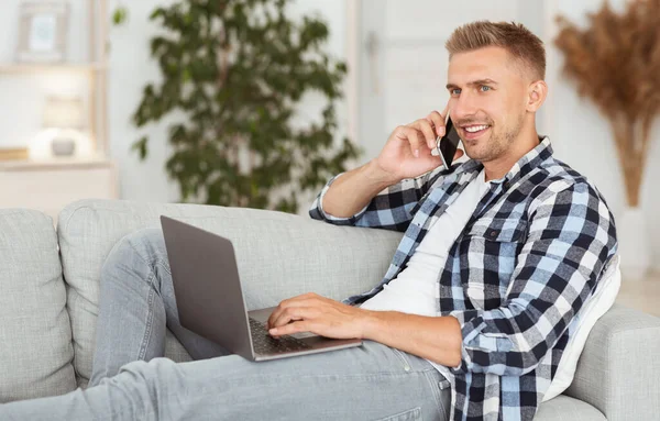 Retrato de cara confiante usando pc falando no smartphone — Fotografia de Stock