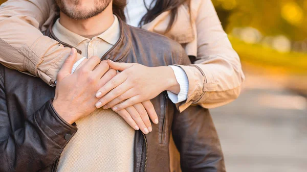 Mulher mãos abraçando seu namorado por trás, desfocado parque de fundo — Fotografia de Stock