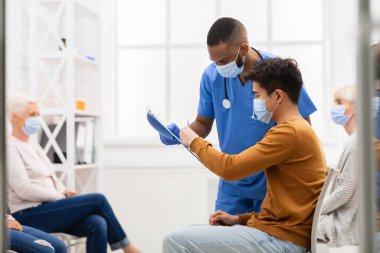 Hastanede Coronavirus aşısı için doktorla hasta imzası.