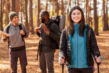 Erkekler güzergahı tartışırken mutlu kız kameraya gülümsüyor