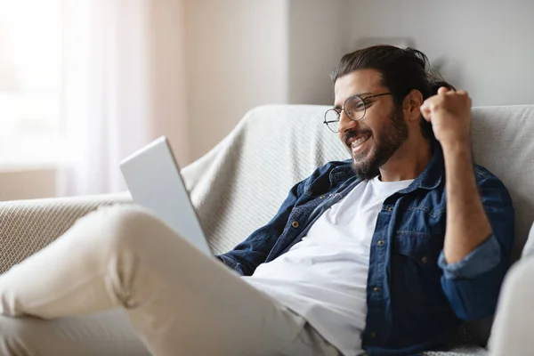 Homem indiano alegre comemorando o sucesso com tablet digital em casa — Fotografia de Stock