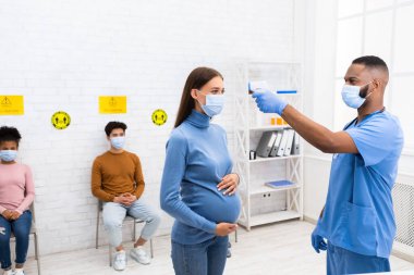 Hastanedeki Hastaya Ateşi Ölçen Sıcaklık Testi yapan Hemşire