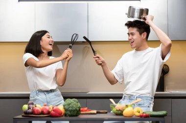 Asyalı Çift Eskrim Tutma Aletleri Kiitchen 'de Eğleniyor