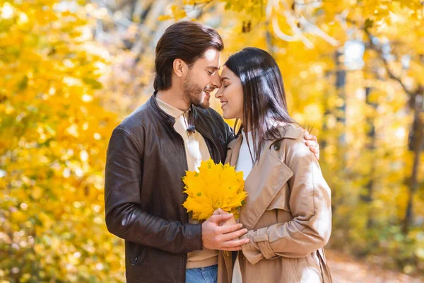Gli amanti romantici con mazzo di foglie d'oro coccole nella foresta — Foto Stock