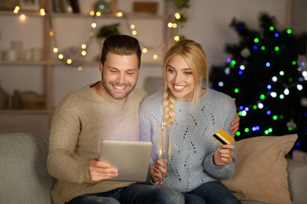 幸せなカップル一緒にクリスマスショッピング、デジタルタブレットを使用して — ストック写真