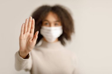 Dünya çapında COVID-19 salgınını durdurun. Koruyucu maskeli Afrikalı Amerikalı kadının eline odaklan.