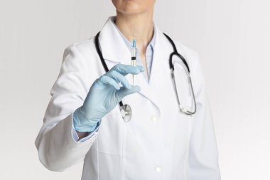 Sağlık, tedavi ve koronavirüse karşı enjeksiyon. Kadın doktor aşı için şırınga tutuyor.