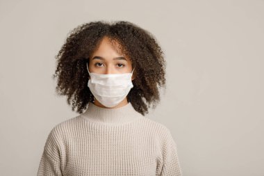Sağlık koruma, sosyal uzaklık ve yeni norm. Tıbbi koruyucu maskeli Afro-Amerikan kadın