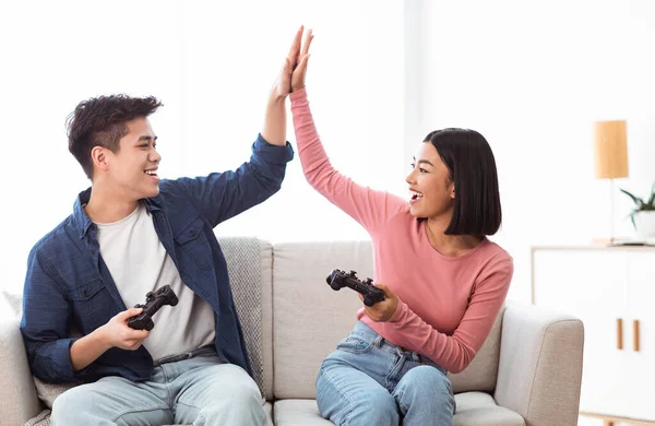 Asiático novio y novia dando alto-cinco ganador videojuego en casa — Foto de Stock