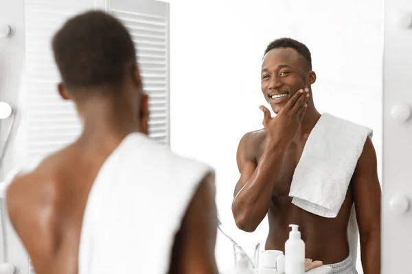 バスルームで手を振った後に滑らかな顔に触れる恥知らずのアフリカ人男性 — ストック写真