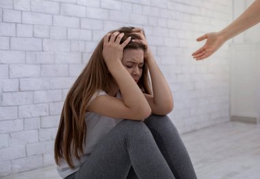 Psikolog eli, üzgün genç kadının depresyondan kurtulmasına yardım ediyor. Duygusal bozuklukların psikoterapisi, travma sonrası stres bozukluğu, endişe.