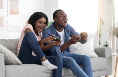 Memleketinde joystickli neşeli Afrikalı Amerikalı erkek ve kadın