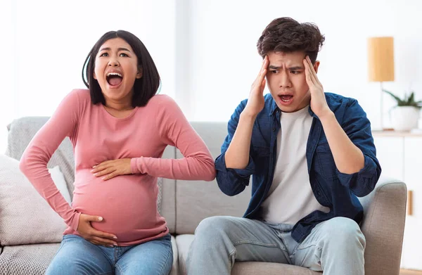 Pregnant Wife Shouting Touching Belly Sitting With Shocked Husband Indoor — Stock Photo, Image