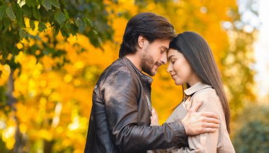 Romantik aşıklar kucaklaşır ve alınlarıyla birbirlerine dokunurlar.