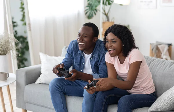Alegre pareja afroamericana jugando videojuegos en casa —  Fotos de Stock