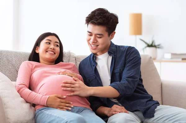 Esposo chino tocando a esposas embarazadas Vientre sentado en casa —  Fotos de Stock