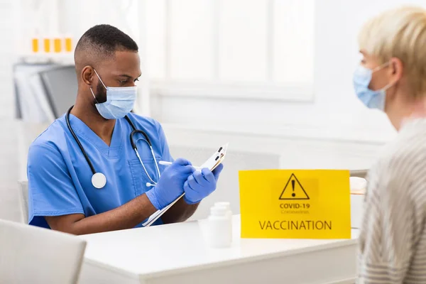 Zwarte arts met coronavirus vaccinatie Afspraak met patiënt in het ziekenhuis — Stockfoto