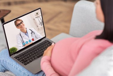 Bilgisayardaki hamile kadın içeride doktorla çevrimiçi danışmanlık yapıyor.