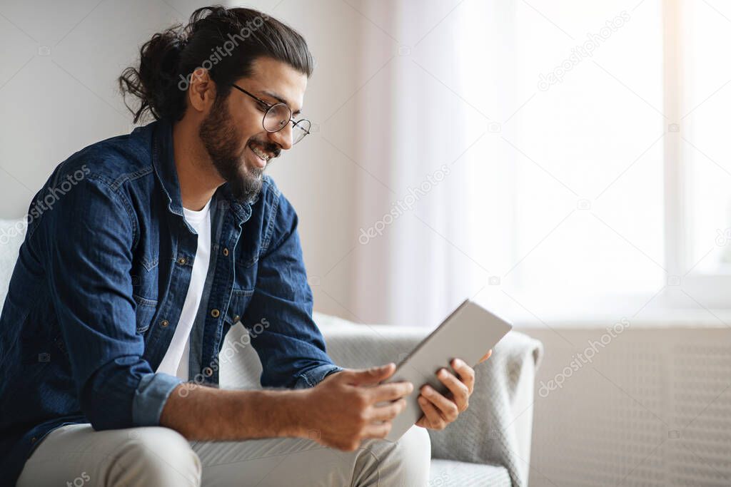 Millennial Western Guy Spending Time With Digital Tablet At Home, Reading News