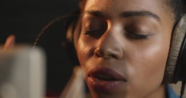 Afrika kökenli Amerikalı şarkıcı şarkısını kulaklıkla ve profesyonel mikrofonla kapatın.