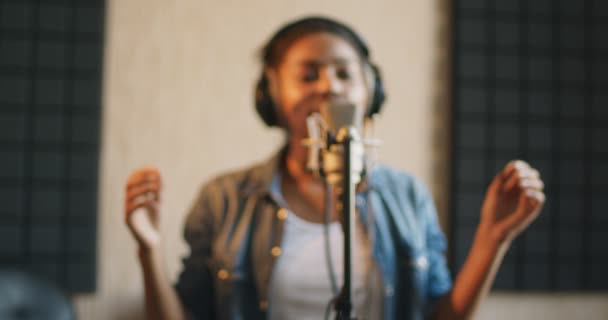 Blurred portrait of african american female singer recording song at sound record studio — Stock Video