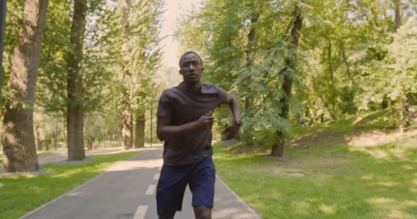 疲倦的美国跑步者停下来休息，继续在城市公园里跑步 — 图库视频影像