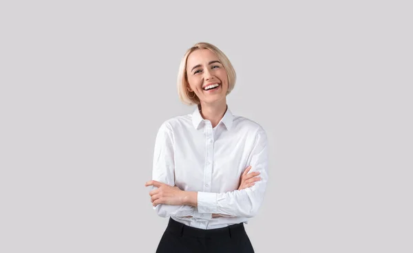 Atractiva mujer de negocios en ropa formal riendo sobre fondo gris claro estudio — Foto de Stock