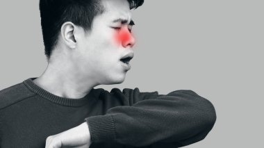 Asyalı adam doğru hapşırdığını, dirseğinden öksürdüğünü gösteriyor.