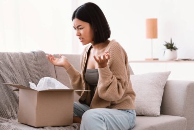 Kızgın Asyalı kadın yanlış kutuyu açıyor, teslimat hatası.