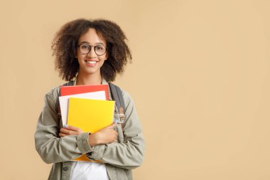 Ders için hazırlık. Gözlüklü Afro-Amerikan bayan öğrencinin stüdyo fotoğrafı. Kameraya bakıyor, arka planda izole edilmiş.