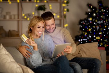 Neşeli karı koca internetten alışveriş yapıyor.