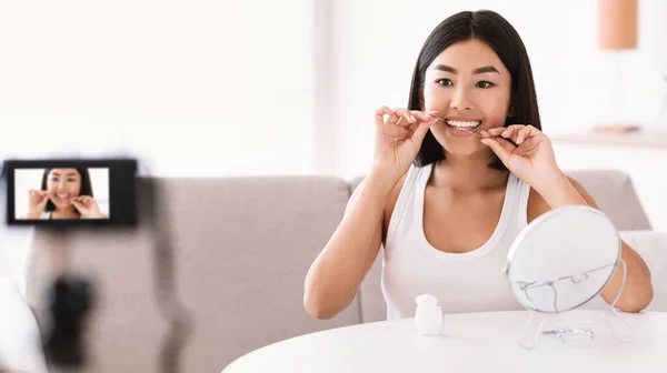 Młoda azjatycka pani za pomocą nici dentystycznej nagrywania vlog — Zdjęcie stockowe