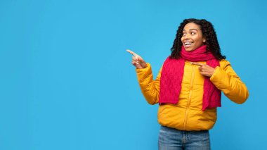 Kışın giyinmiş Afrikalı Kadın Parmakları Yanda, Mavi Arkaplan