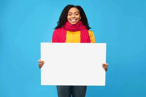 Szczęśliwy czarny kobieta gospodarstwa pusty papier pokładzie na niebieskim tle — Zdjęcie stockowe
