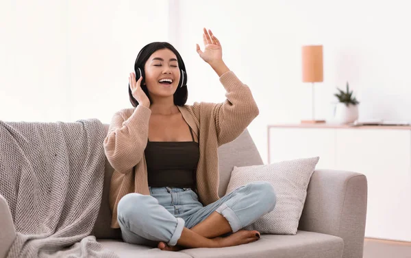 Asian student listening to music in headphones and dancing — Stock Photo, Image