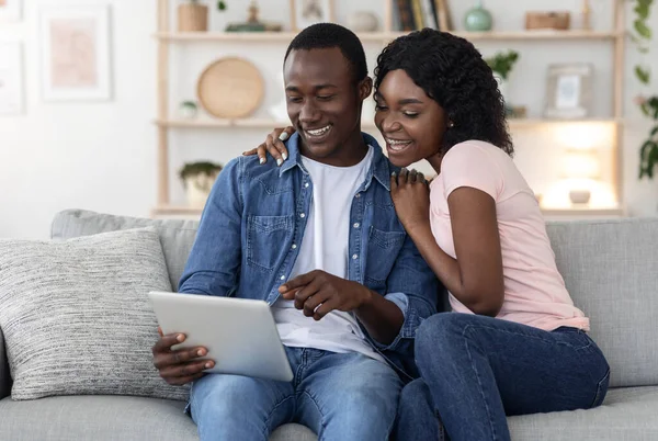 Família negra alegre usando tablet digital na sala de estar — Fotografia de Stock