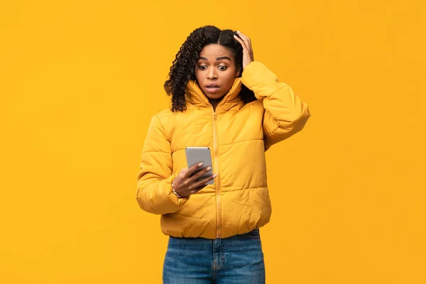 Μαύρη γυναίκα με κινητό τηλέφωνο ανάγνωση κακό μήνυμα σε κίτρινο φόντο — Φωτογραφία Αρχείου