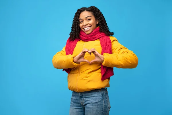 Позитивная афроамериканская леди Жестикулирующее сердце на голубом фоне — стоковое фото