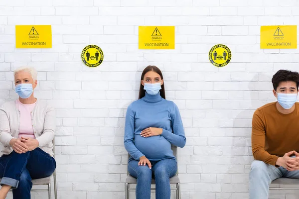 Menschen, die darauf warten, gegen Coronavirus geimpft zu werden, sitzen im Krankenhaus — Stockfoto