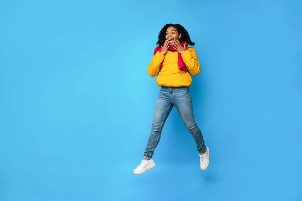 Excited Black Woman Jumping Looking Aside Over Blue Background — Stock Photo, Image