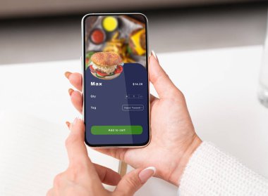 Ofiste ya da salgın sırasında evde yemek dağıtılıyor. Akıllı telefon tutan iş kadınının elleri