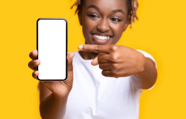 Heyecanlı Afrikalı kadın beyaz ekranlı akıllı telefonu gösteriyor.
