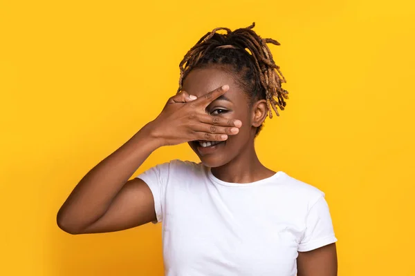 Alegre Africano americano senhora jogar esconder e procurar no amarelo — Fotografia de Stock