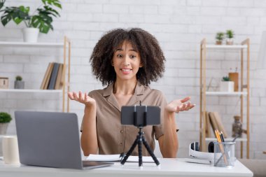 Bilgi, ders, hatalar ve online sorular. Şaşırmış Afrikalı Amerikalı kadın kollarını yana açıyor.