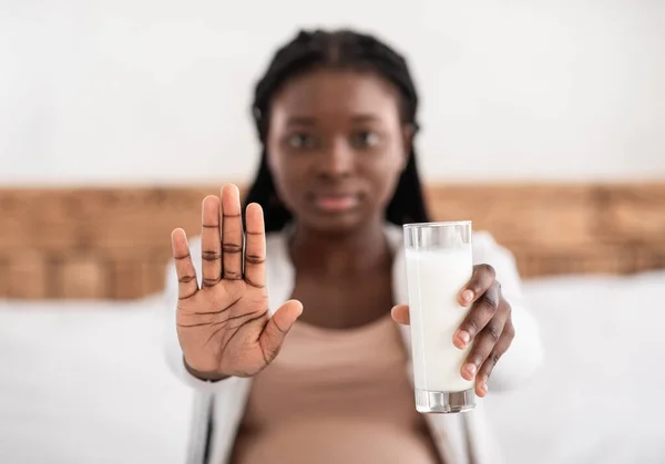 Těhotná afroameričanka drží sklenici mléka a ukazuje stop gesto — Stock fotografie